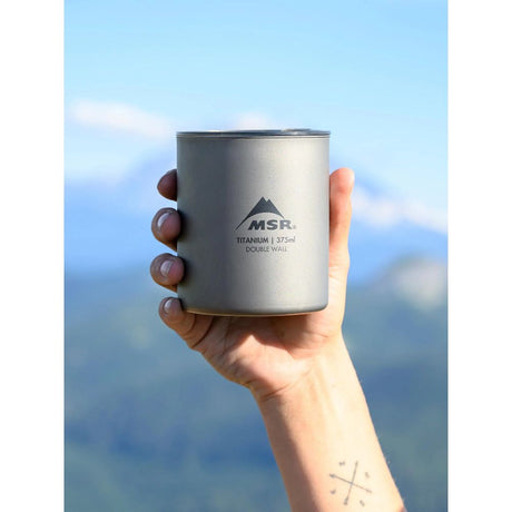 MSR Titan Double Wall Mug held up in the air by hand